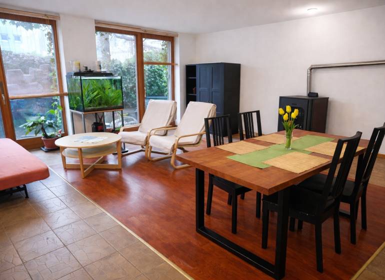 Obývací pokoj ve 3pokojovém bytě s podlahou s dřevěným dekorem, jídelním stolem a akváriem.