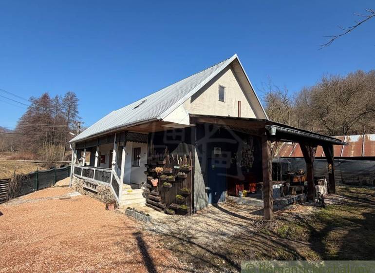 Rodinný dům v Ratkovském Bystrom se sedlovou střechou a dřevěnou verandou.