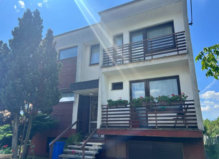 Rodinný dům na Tálové ulici ve Velkém Orvišti se dvěma balkony, dřevinami a garáží.