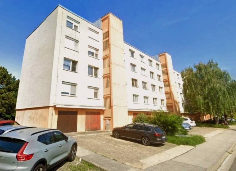 Bytový dům na Kalištnej ulici v Bratislavě - Devínské Nové Vsi, parkoviště v popředí.