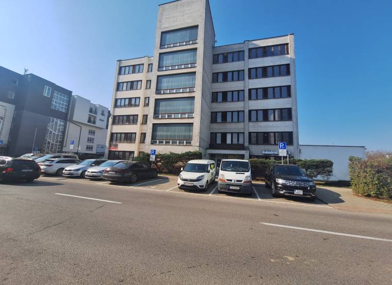 Budova na Tulskej ulici ve Zvolenu, před kterou parkují auta.