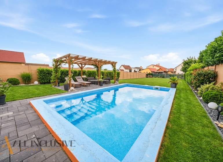 Rodinný dům v Horním Mýtě: Bazén, pergola a upravená zahrada na zahradě.