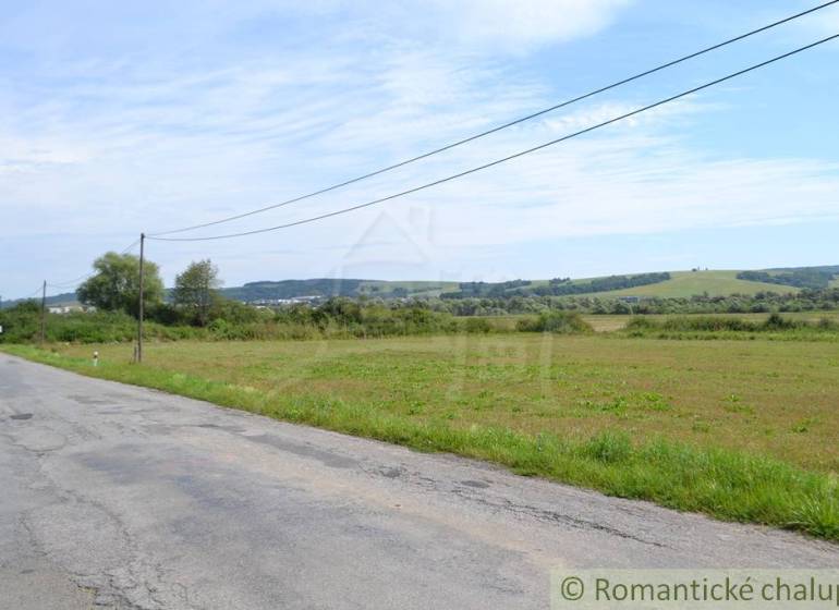 Zemědělské a lesní pozemky v okolí Šandalu, cesta lemovaná loukami a stromy.