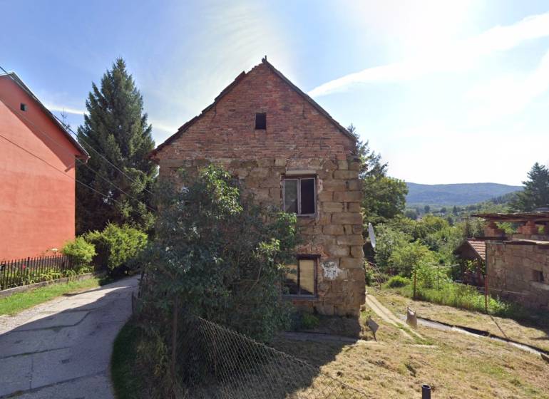 Rodinný dům na ulici Ivana Kraska v Handlové s cihlovou fasádou a zahradou.