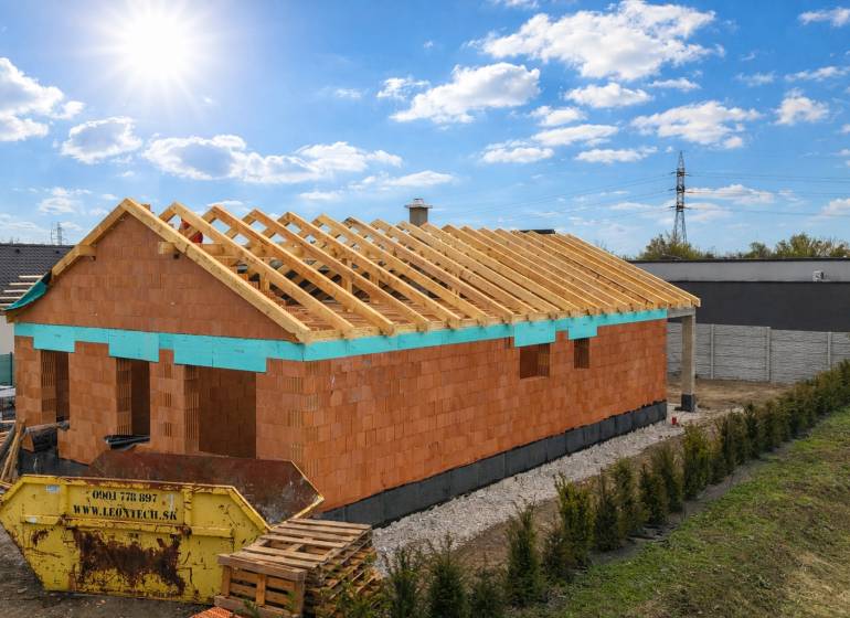 Rozestavěný rodinný dům na Karasově ulici v Senci s viditelnou střešní konstrukcí.