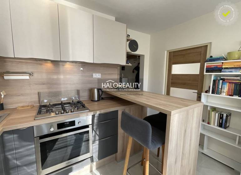 Kuchyně v 1-pokojovém bytě s kuchyňským pultem a spotřebiči.