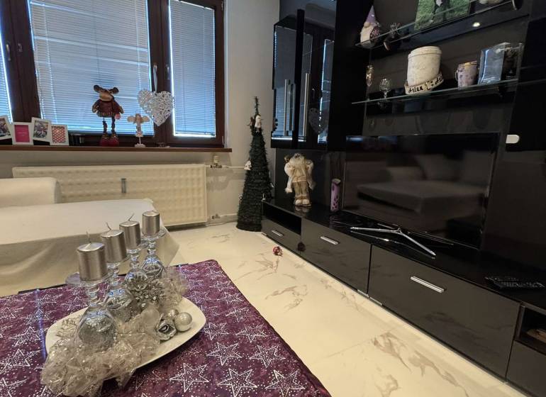 Obývací pokoj v 2-pokojovém bytě s mramorovou podlahou a sváteční výzdobou.