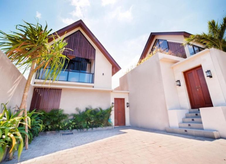 Vila na Bali se zahradou a palmami, moderní architektura, kamenný chodník.