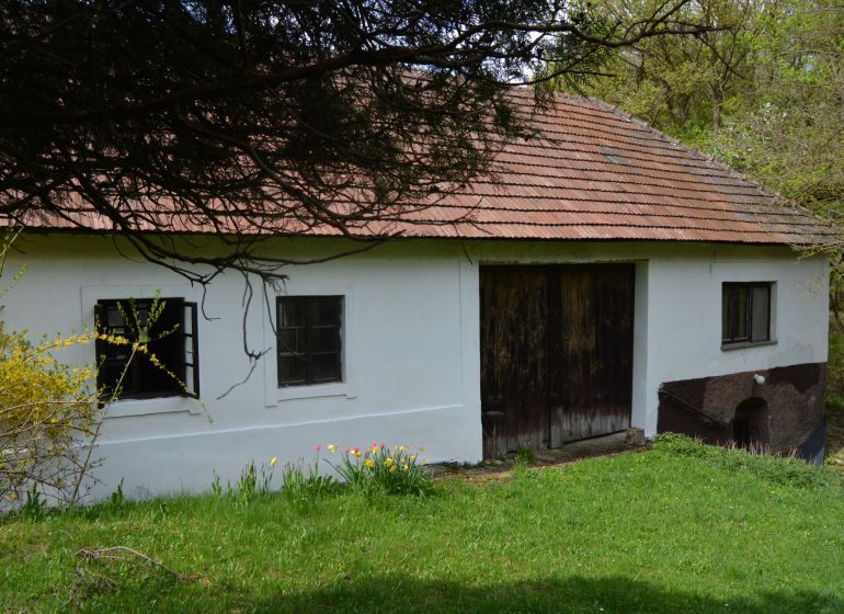Rodinný dům v Bukovci se šikmou střechou a dřevěnými branami.