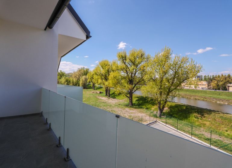 Balkón s výhledem na řeku a zeleň u Moravanské ulice v Banke.