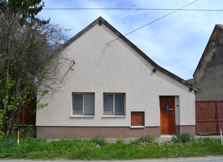 Rodinný dům v Horních Salibách s jednoduchou fasádou a předzahrádkou.