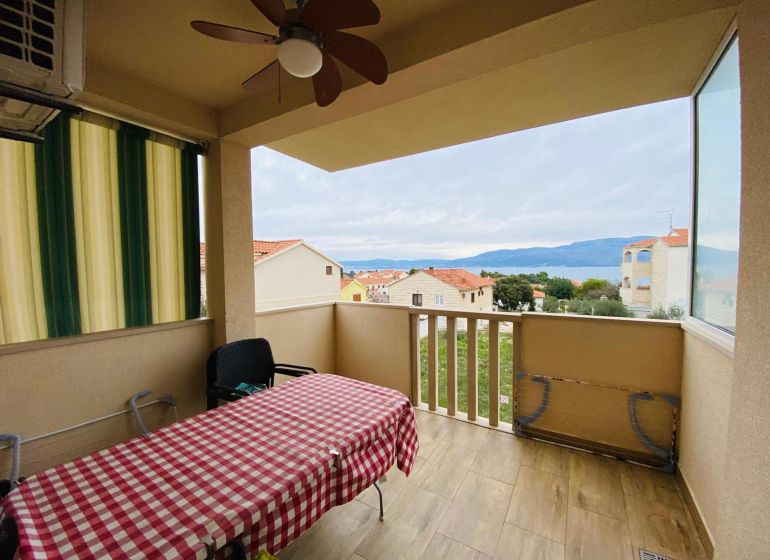 Rekreační apartmán na Brači: terasa s výhledem na moře a podlaha s dřevěným dekorem.