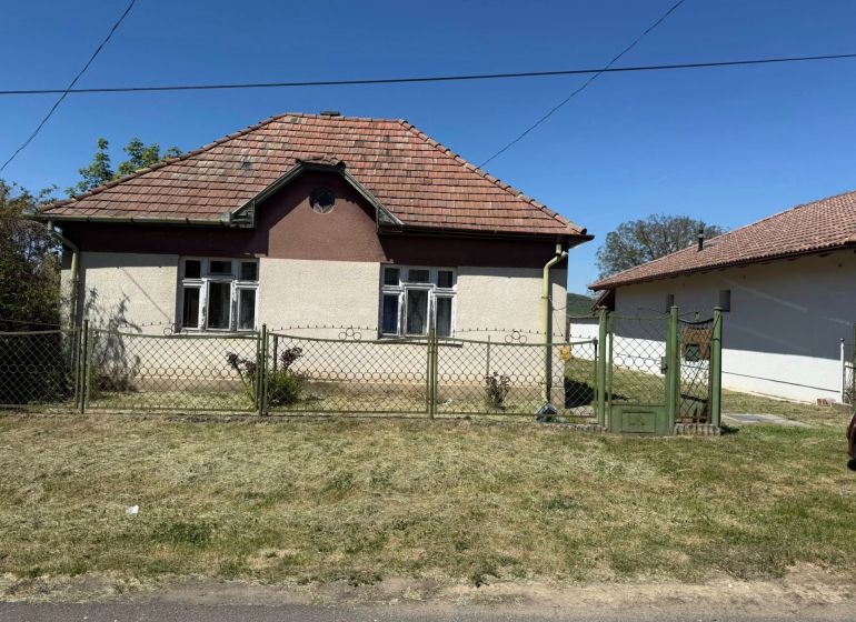 Rodinný dům v Honte má šikmou střechu a je oplocen kovovým plotem.