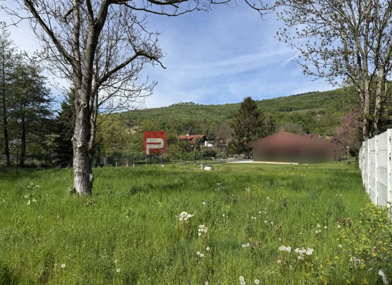 Pozemky na bydlení v Borince s výhledem na zeleň a okolní kopce.