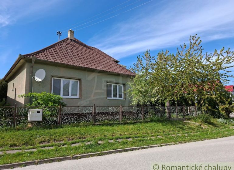 Rodinný dům v Orešanech s červenou střechou a udržovanou zahradou.