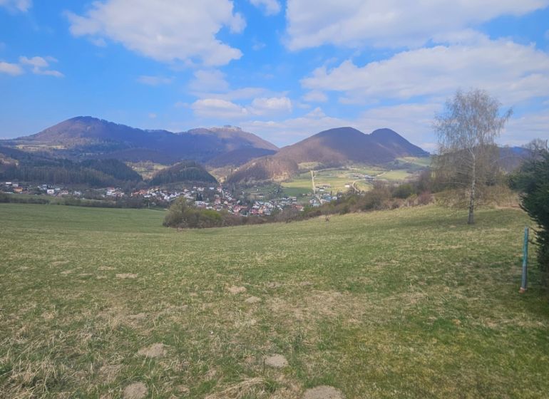 Rekreační pozemky v Lysicích s výhledem na kopce a modrou oblohu.