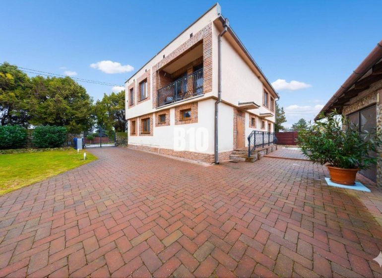 Rodinný dům ve Štvrtku na Ostrově s prostorným dvorem a zahradou, cihlový design.