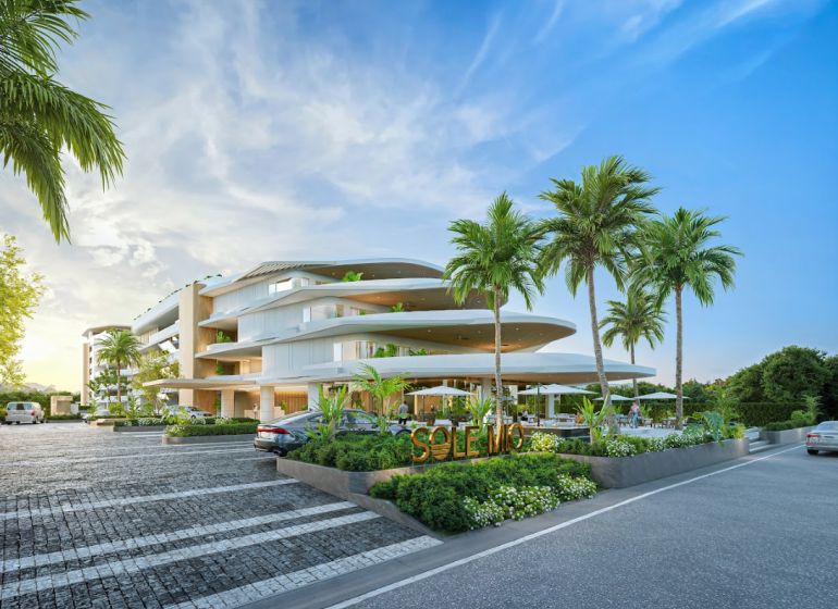 Výstavba bytů v Phuketu s moderní architekturou, obklopená palmami a parkovací plochou.