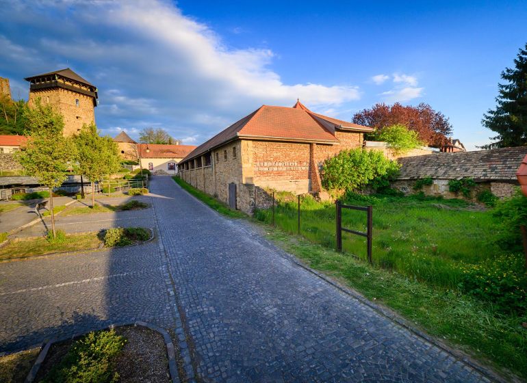 Kamenný chodník vedoucí podél historické budovy v Pozemcích - komerčních ve Fiľakovu.