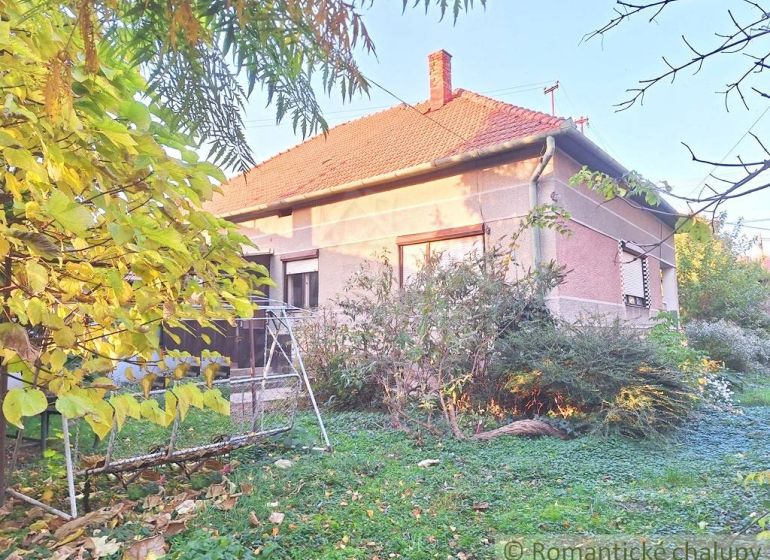 Rodinný dům v Gbelcích se zahradní houpačkou, obklopený zelení a keři.