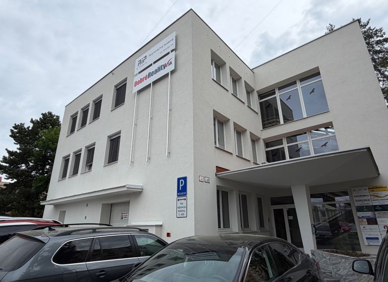 Budova kanceláří na Dlouhé ulici v Prievidzi se zaparkovanými auty.