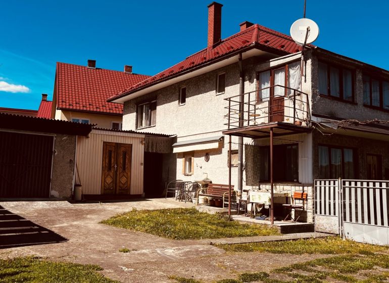 Rodinný dům v Nové Kelči, Nová Kelča s dvorem, garáží a balkonem pod modrou oblohou.