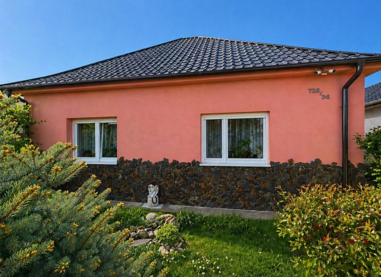 Rodinný dům na Nové cestě v Jelce, okres Galanta, má růžovou fasádu a taškovou střechu.