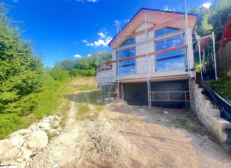 Rodinný dům v rekonstrukci s lešením, obklopený přírodou v Badíně, okres Banská Bystrica, Slovensko.