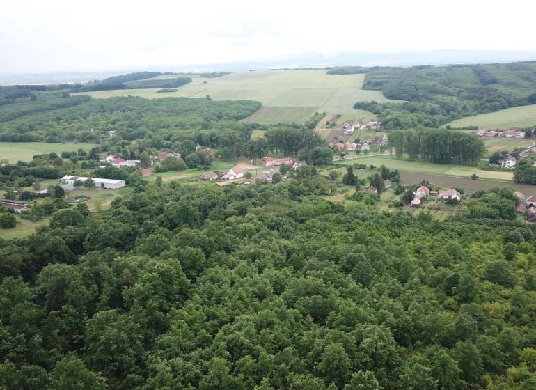Letecký pohled na zemědělské a lesní pozemky v okolí Trebušovců s vesnickým osídlením.