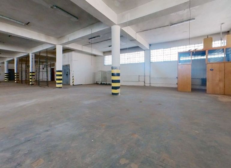Skladový prostor s betonovou podlahou, sloupy a prosvětlenými okny na Lieskovské cestě, Zvolen.