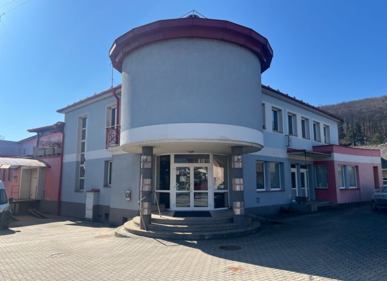 Budova s obloukovým vchodem v Kremničce, Banská Bystrica, sloužící pro sklady a haly.