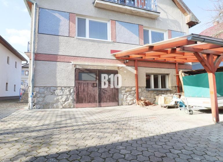 Rodinný dům v Turanech se zpevněnou příjezdovou plochou a přístřeškem pro auta.