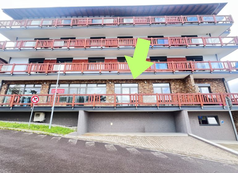 Budova s balkony a kamennou fasádou, obchodní prostory v Donovalech, okres Banská Bystrica.