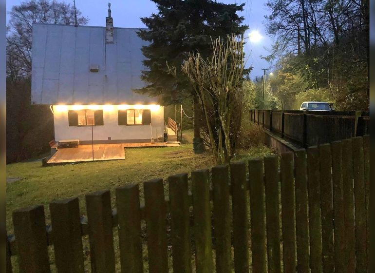 Rodinný dům v Horních Otrokovicích na ulici Horní Otrokovice s osvětlenou terasou a bránou.