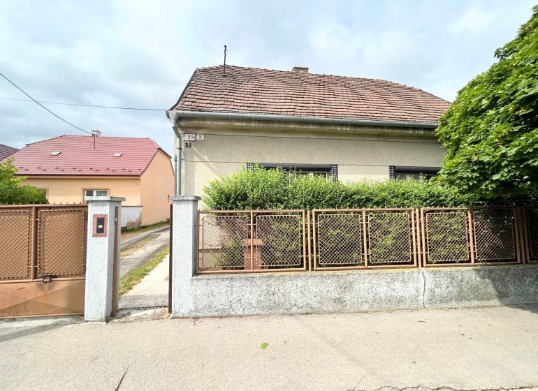 Rodinný dům na Krajinské ulici v Bratislavě - Podunajských Biskupicích s plotem a předzahrádkou.