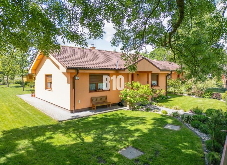 Rodinný dům v Bíľkových Humencích obklopený udržovanou zahradou a zeleným trávníkem.