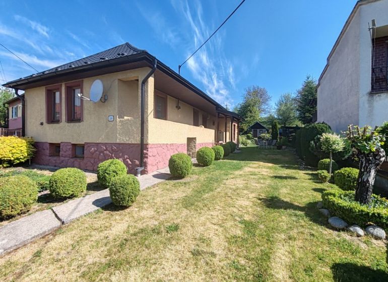 Rodinný dům na Hlavní ulici v Banském s udržovanou zahradou a upraveným trávníkem.