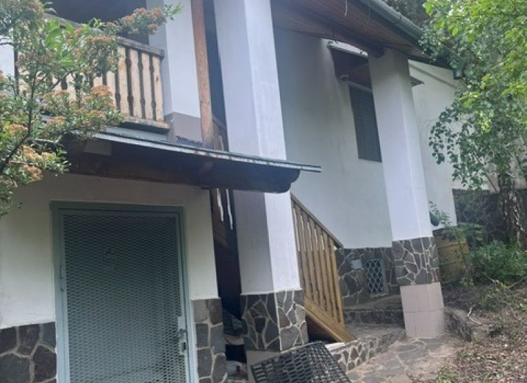 Chata v Jabloňově nad Turňou, obklopená zelení, s terasou a kamenným obkladem.
