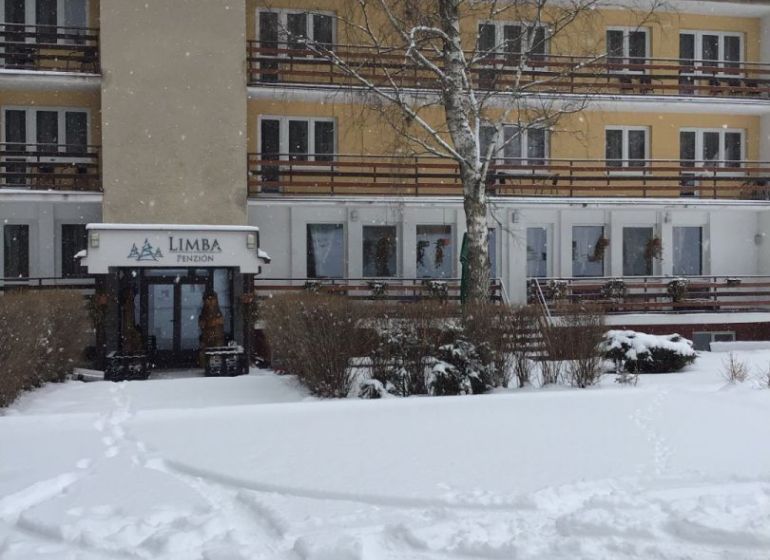 Hotel a penzion v Liptovském Jánu se zasněženou střechou a exteriérem.