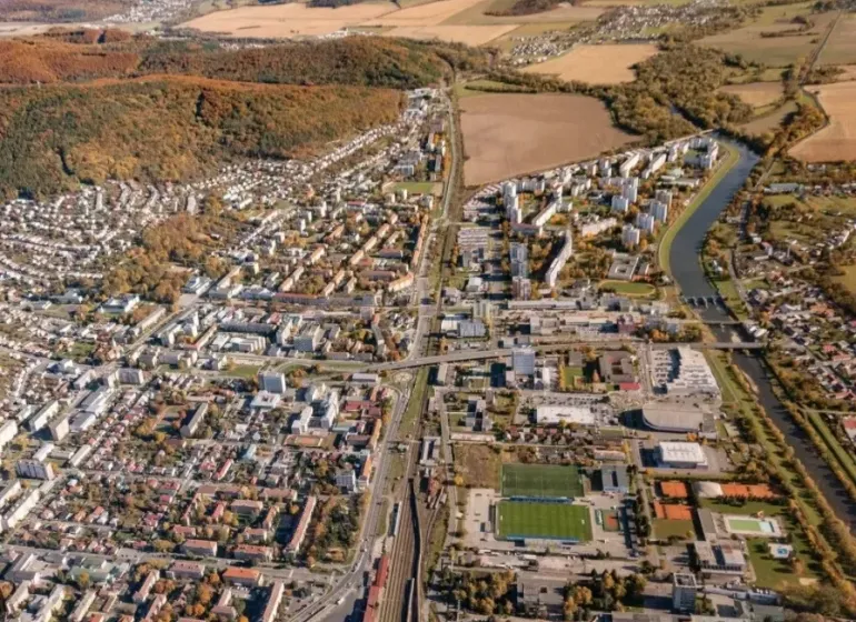 Letecký pohled na Humenné se zemědělskými a lesními pozemky a urbanizovanou zástavbou.
