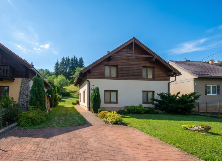 Rodinný dům v Horní Lehotě obklopený zahradou s trávníkem a příjezdovou cestou.
