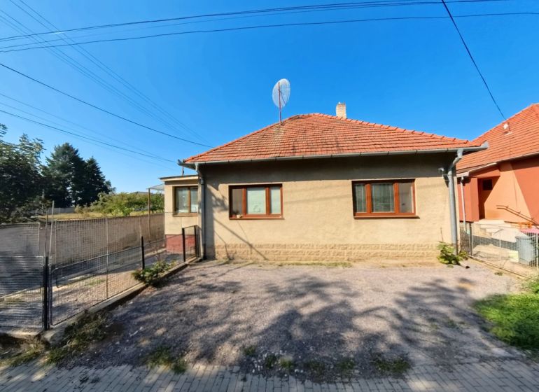 Rodinný dům na Školské ulici v Tesárských Mlýňanech s upraveným dvorem a plotem.