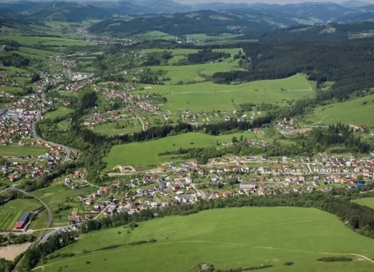 Letecký pohled na zemědělské a lesní pozemky v Olešné s viditelnou zástavbou.
