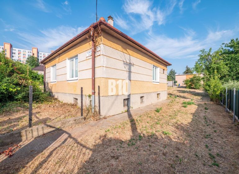 Rodinný dům v Nitře s travnatým okolím, u něj vede úzká cesta.