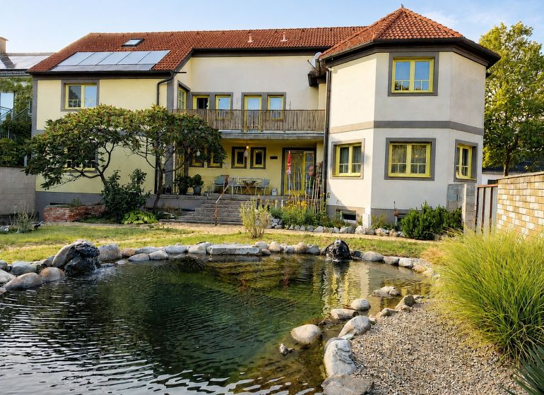 Rodinný dům v Podersdorf am See s velkou zahradou, rybníkem a solárními panely.