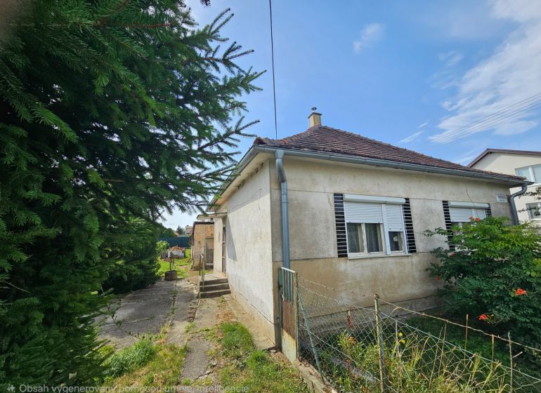 Rodinný dům na Dvorčanské ulici v Nitře s malou zahradou a starší fasádou.