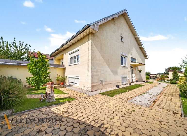 Rodinný dům na ulici Vojtechovce v Novém Životě obklopuje udržovaná zahrada s chodníkem.