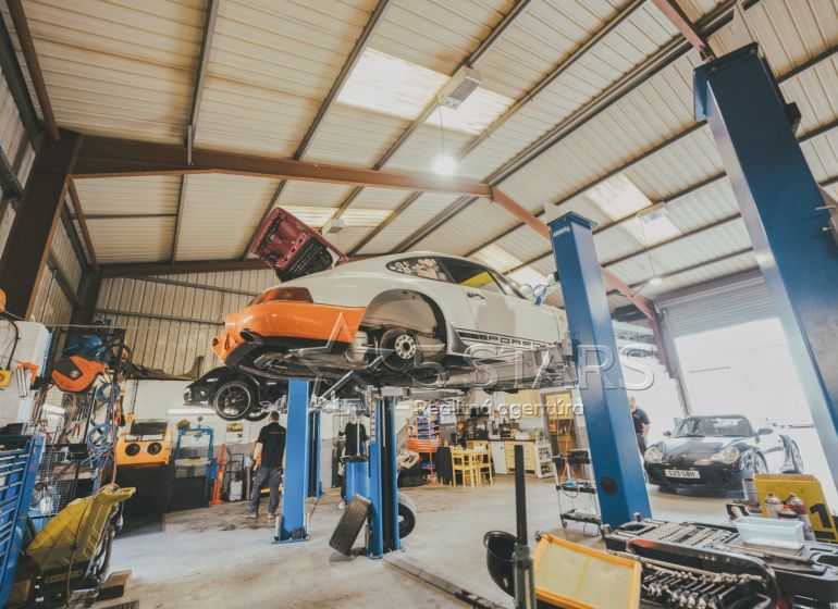 Autoservis se dvěma zvedáky, vozidly a nářadím v prostoru zvláštních nemovitostí.