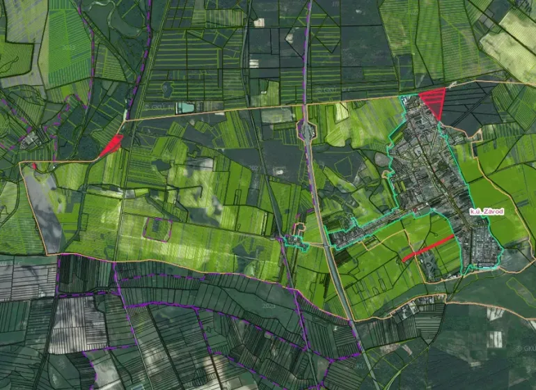 Letecký pohled na zemědělské a lesní pozemky v obci Závod se silniční infrastrukturou.