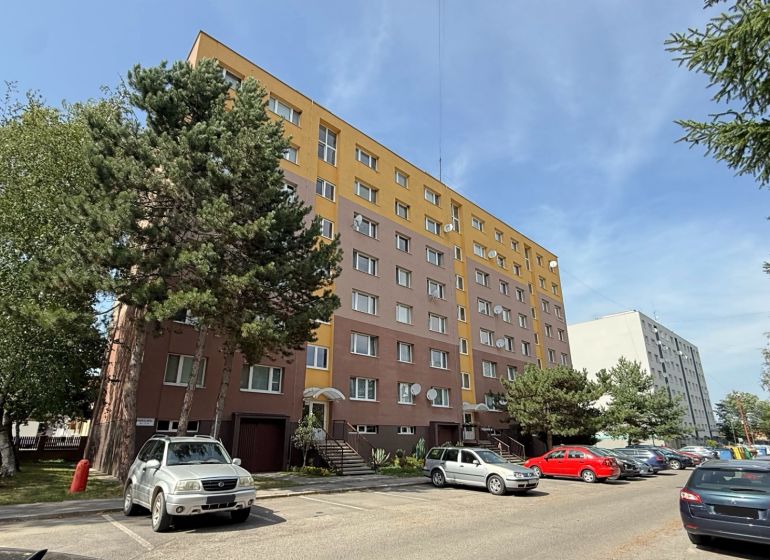Ulice Mudrochova v Rajci ukazuje bytový dům a parkoviště pro 2-pokojové byty.